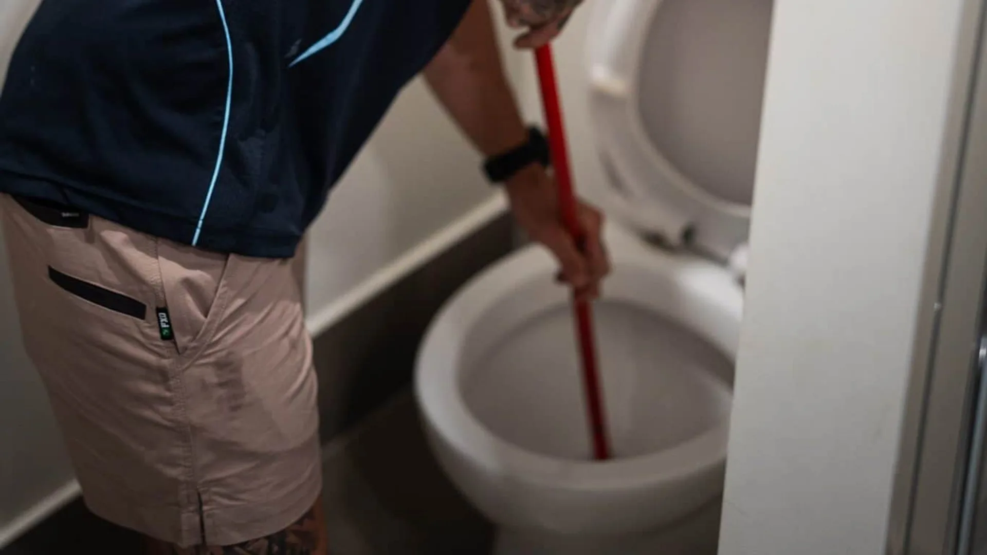 Plumber clearing an overflowing toilet